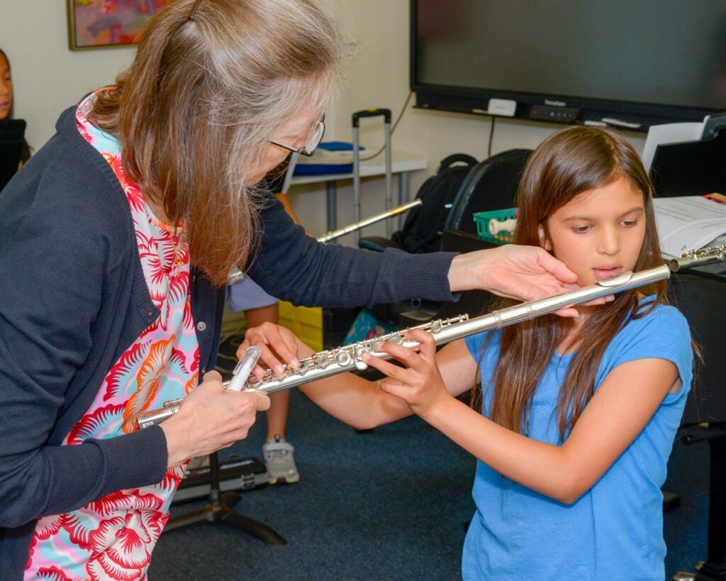 teacher helping student play the flute