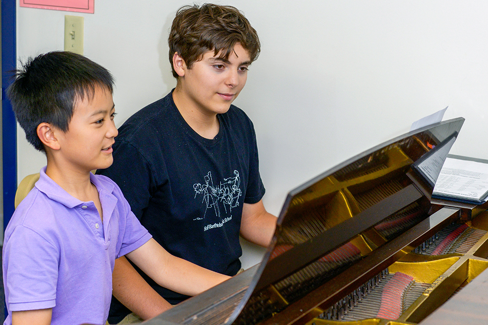 two young males playing the piano