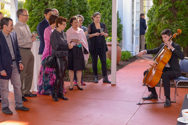 student playing cello for adult audience