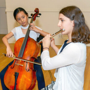 Girl playing the cello with girl playing the flute
