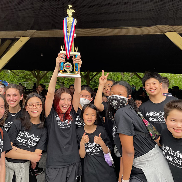 Smiling Orchestra Students with Trophy