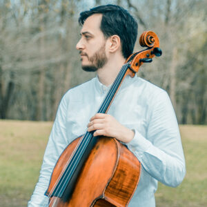 Man looking sideways standing with a cello